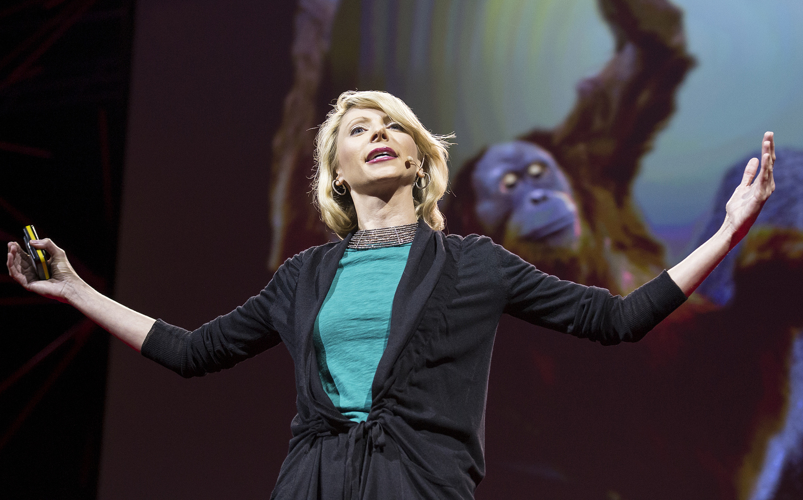 Amy Cuddy demonstrates a classic power pose used by humans and chimps alike — spreading your arms wide to appear more powerful. Photo: James Duncan Davidson