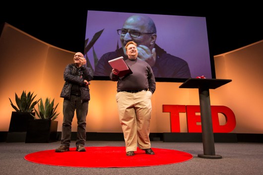 Senior Fellow Taghi Amirani receives the first-ever TED Fellow Hero award from Tom Rielly on the Fellows Talk stage.