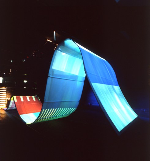 Digital Wave (1998): Participant faces are manipulated and streamed down a giant wave shaped interactive digital sculpture measuring 45 x 6 x 10 ft. 