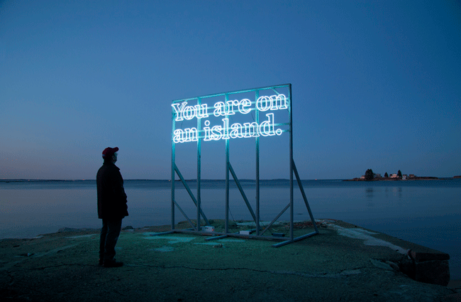 "You are (on) an island" was originally made in 2011 for the Sacred and Profane art festival on Peaks Island, Maine. Eggert and her collaborator toured the sculpture around the UK on the back of a flatbed truck for two weeks in January 2013. In this image, it is shown parked next to the picturesque coast of North Wales. The word ‘on’ blinks rhythmically on and off. For the moment that single word remains unilluminated, a new phrase with a different meaning emerges. Photo: Alicia Eggert