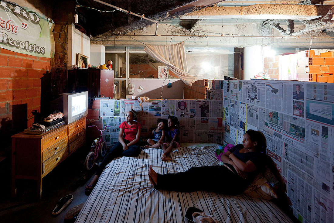 In an exercise of ingenuity, inhabitants like this family typically mark their space with whatever materials they can find or purchase.  Here, newspaper becomes wallpaper.