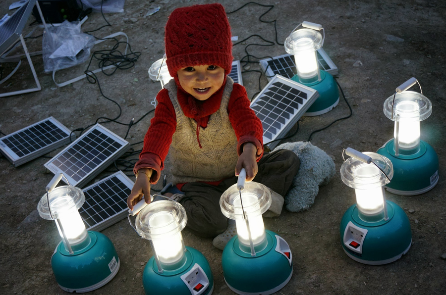 A Sumda Chenmo child experiences solar lanterns for the first time. Solar improves safety, productivity and indoor air quality. Photo: Stephanie Wolcott
