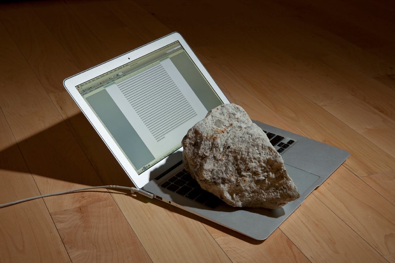 Present Perfect (2013). A rock sits on the keyboard of an open laptop, typing the letter Y into in infinity in Microsoft Word. Image courtesy of Alicia Eggert." 
