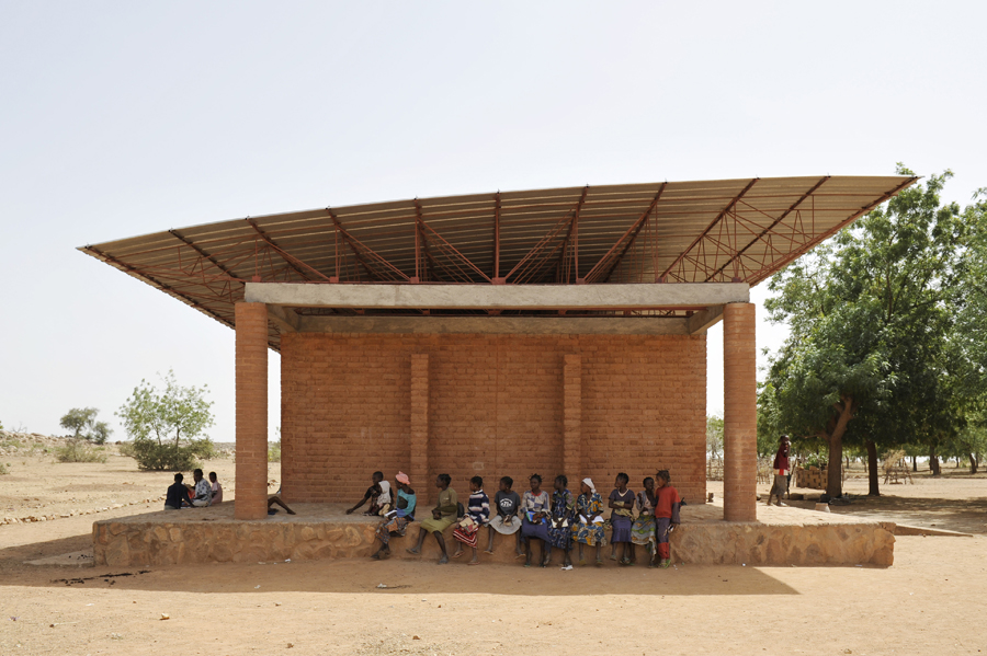 A group of women and girls enjoy the shade outside the primary school. After completion of the building, local authorities opted to pay for the teaching staff. Photo: Erik-Jan Ouwerkerk