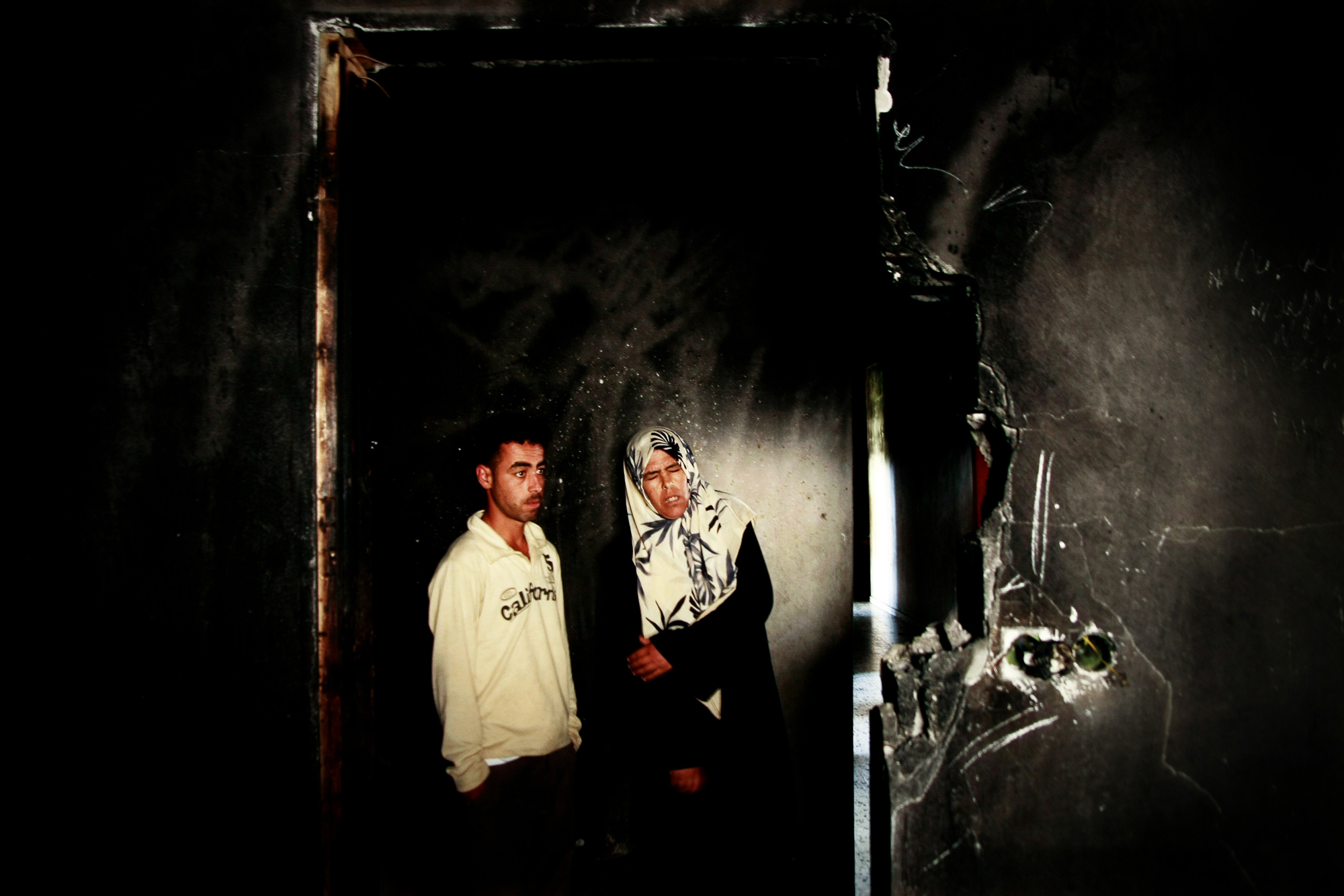 Sabha Abu Halima and her son Ahmed Abu Halima in their house, which was destroyed by fire from phosphoric bombs dropped by Israel during Gaza War. Photo: Eman Mohammed 