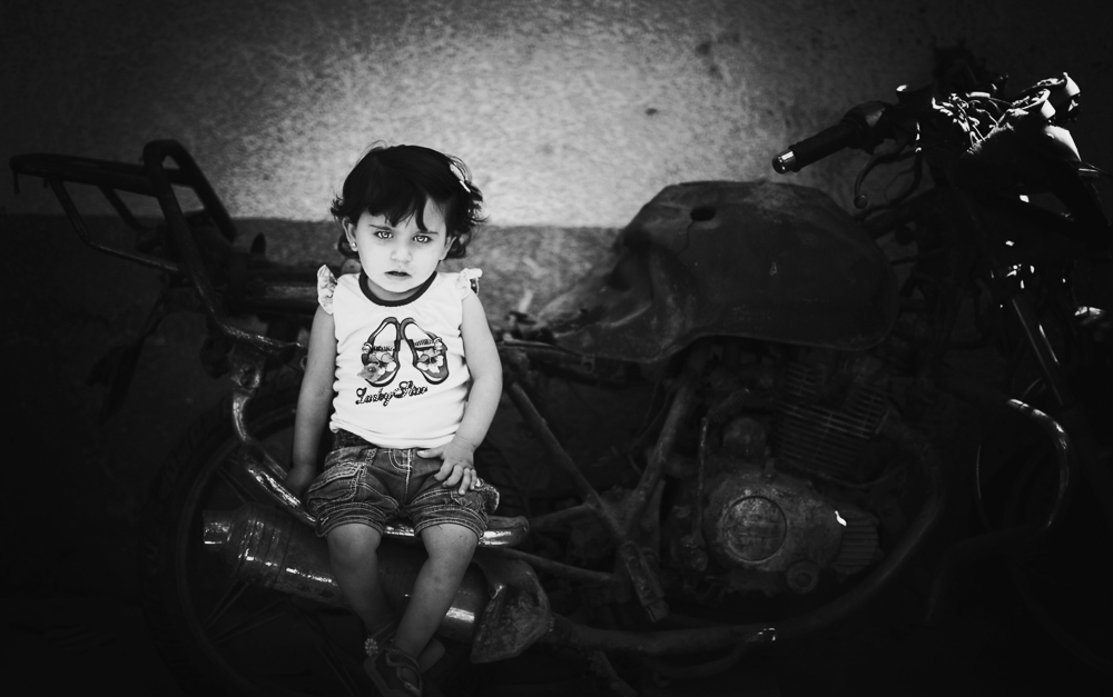 Islam Qreqe ,14 months old, sitting on a burned motorcycle. Her father, uncle and 2-year-old brother were riding it when they were targeted, bombed and killed by a rocket fired from an Israeli aircraft drone. Four months later, Islam was born and named after her brother. (Stay tuned for a gallery of Eman's iWar images next week.) Photo: Eman Mohammed