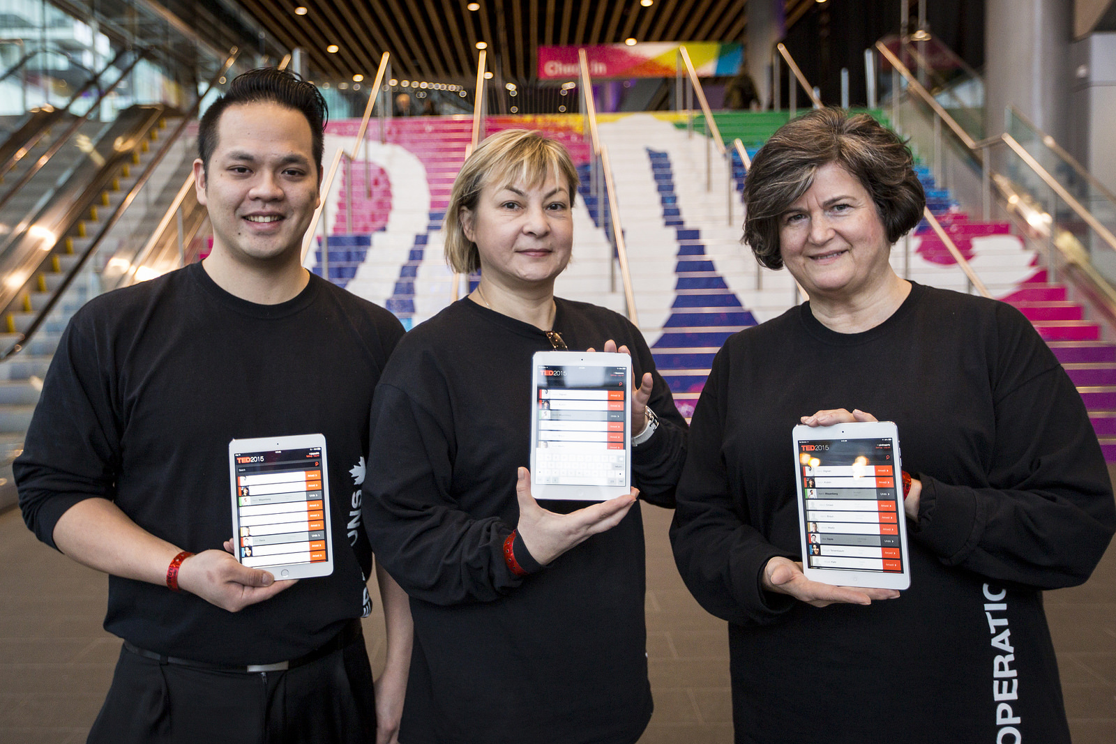 At our registration desk, an app helps volunteers know when attendees have arrived. These volunteers pose in front of the "Dare" stairs, at the entrance to TED2015. Photo: Ryan Lash/TED