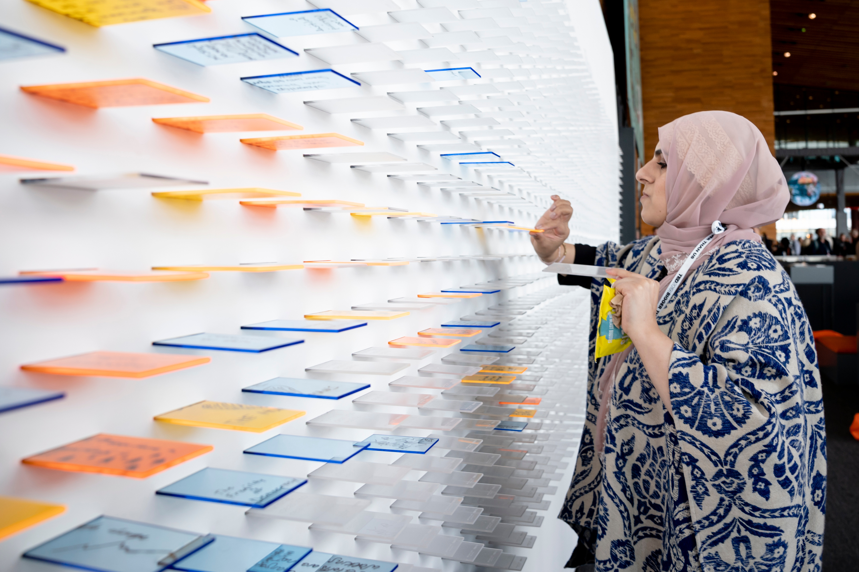 Attendee Fajir Amin adds an idea to the "moodbeam" installation at TED2019. The board was designed by Domestic Data Streamers and presented by Brightline Initiative.