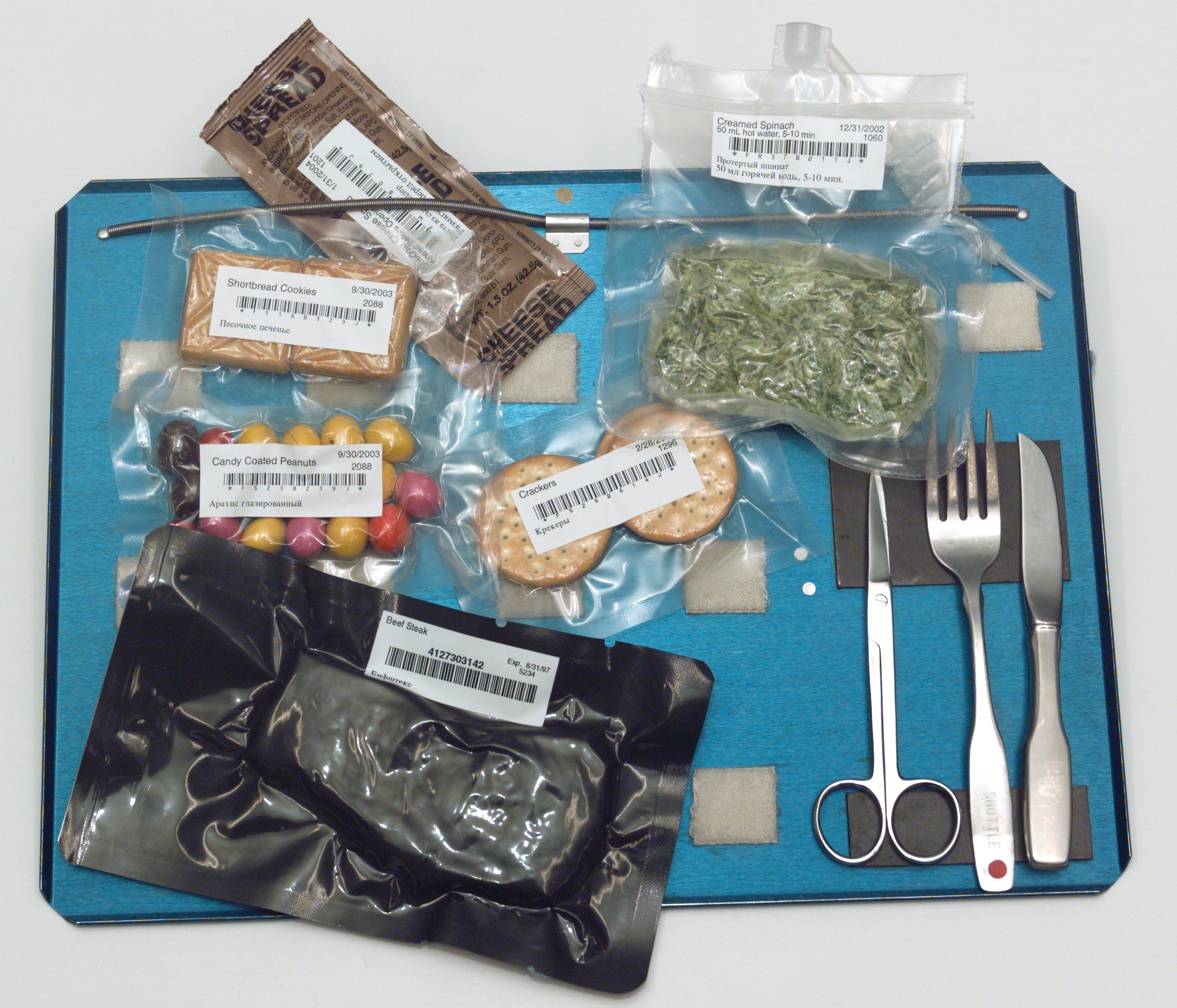 Magnets, springs, and velcro keep cutlery and food packets from floating away. Photo courtesy of NASA.